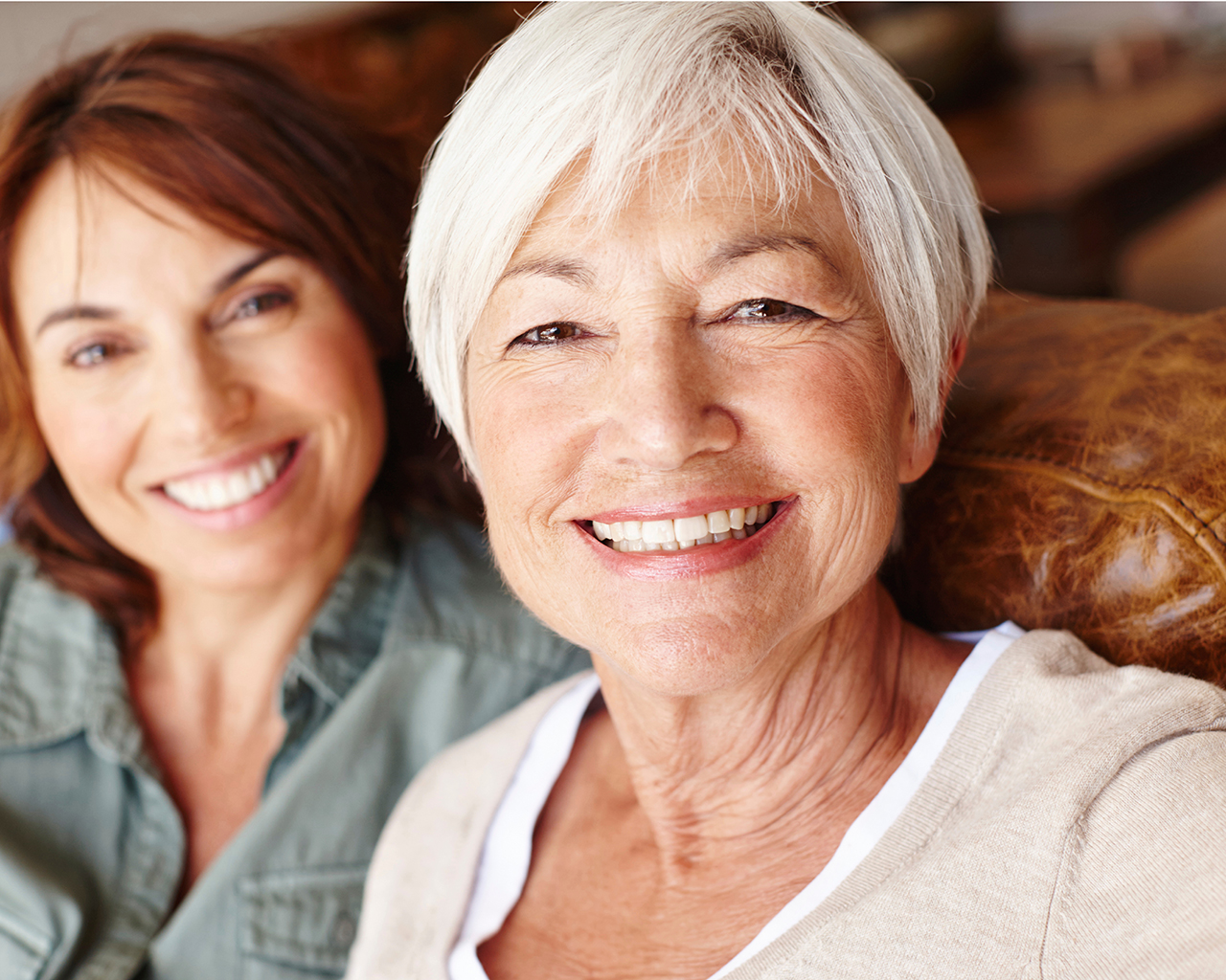 Two women sitting on couch smilng