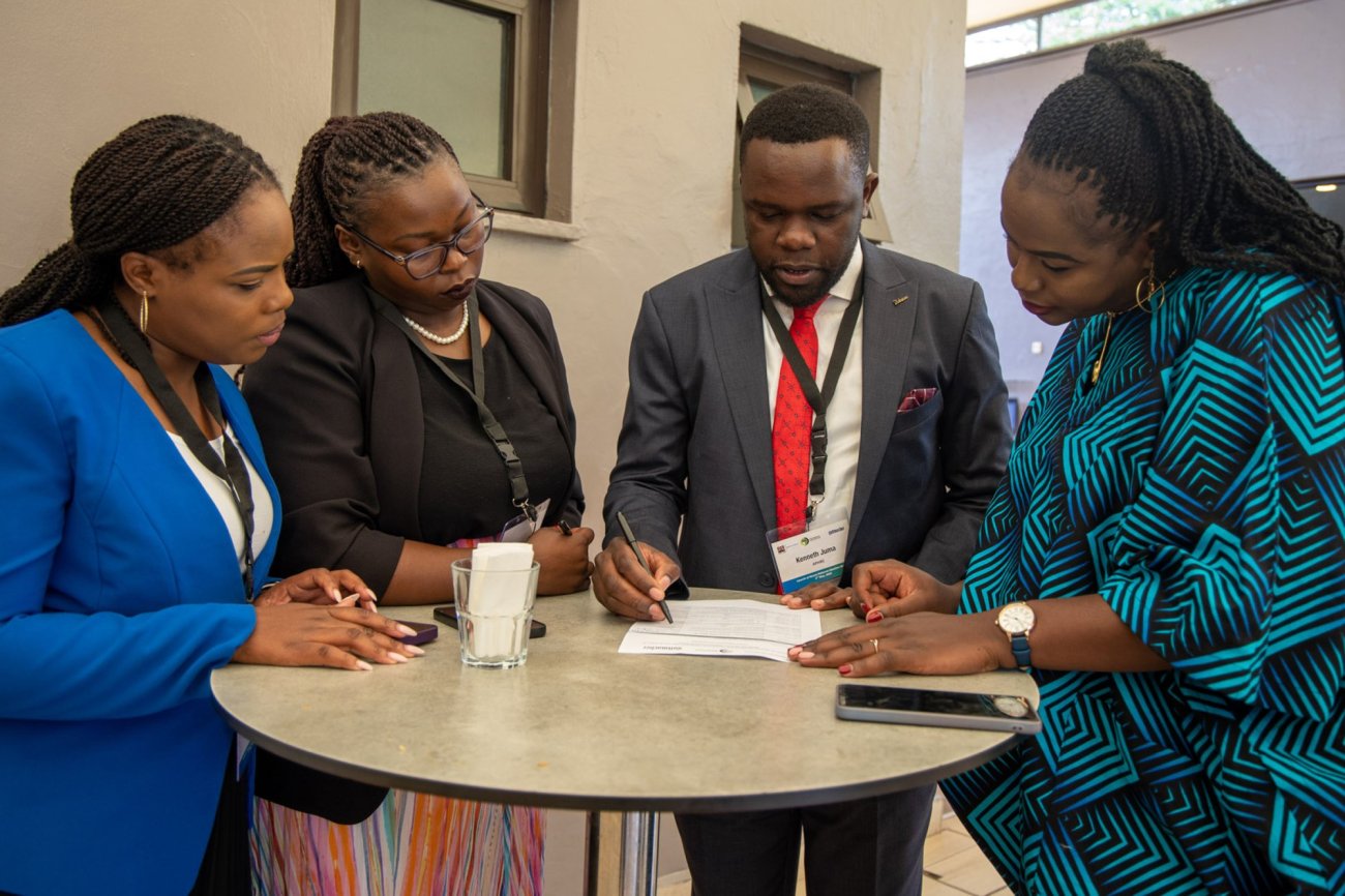 APHRC staff and an emcee looking over a press release at the Kenya Abortion Study National dissemination event in Nairobi.  