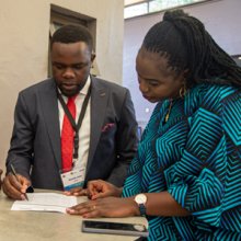 APHRC staff and an emcee looking over a press release at the Kenya Abortion Study National dissemination event in Nairobi.  