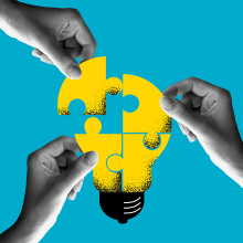 hands putting together puzzle pieces forming a lightbulb